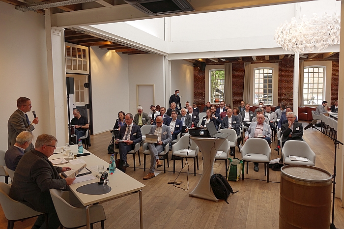 Manfred Wagner (links stehend) begrüßt die Teilnehmerinnen und Teilnehmer aus ganz MIttelhessen beim Runden Tisch für die „Transformationsstrategien für Regionen der Fahrzeug- und Zulieferindustrie“ (Foto: Regionalmanagement Mittelhessen/Manuel Heinrich)